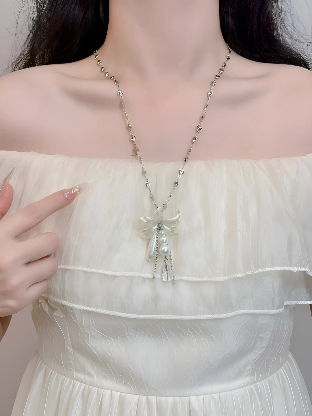 Women's necklace with geometric teardrop and lily flower pendant on a chain