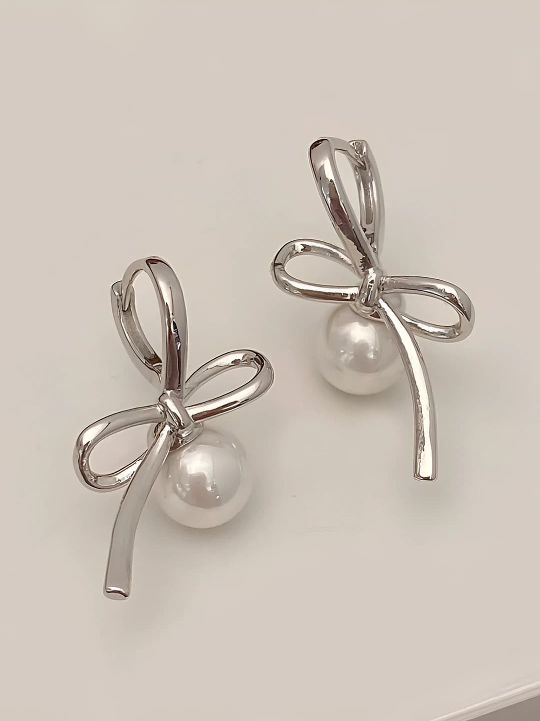 Silver bow pearl stud earrings