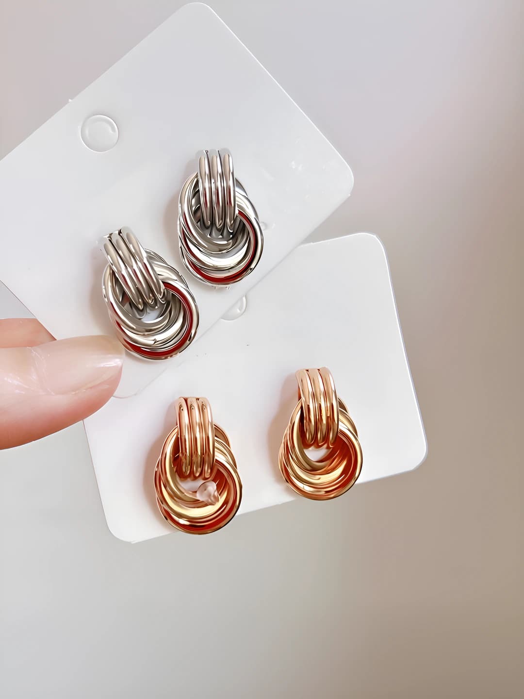 Women's metal stud earrings with elliptical shape, cutout, twisted and knotted design