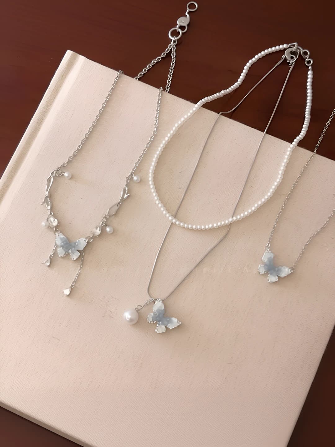 Women's short chain with blue crystals, butterfly and two layers of pearls, summer accessory in sweet style