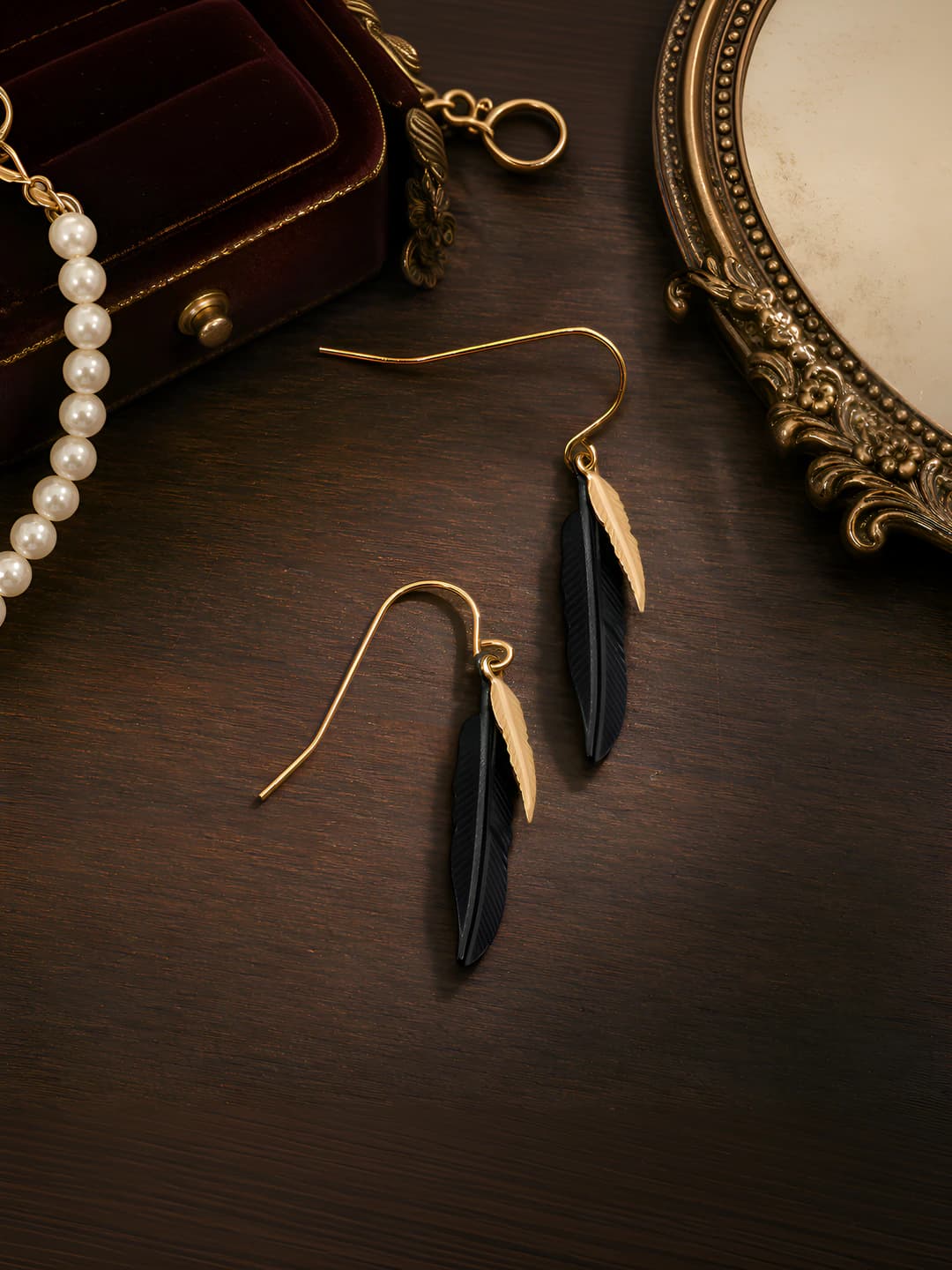 Women's feather dangle earrings, black and gold, electroplated, leaf design