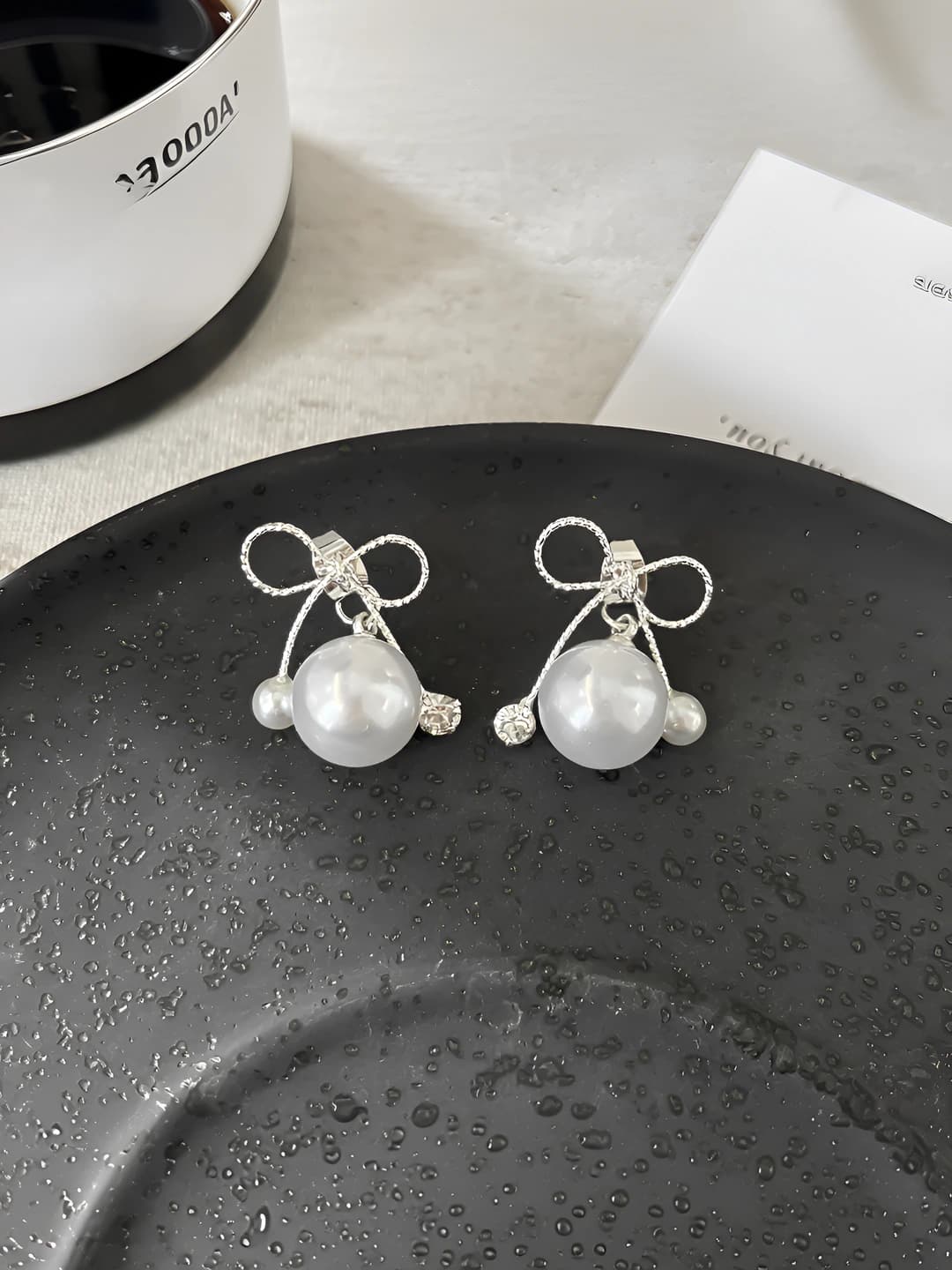 Silver bow pearl stud earrings