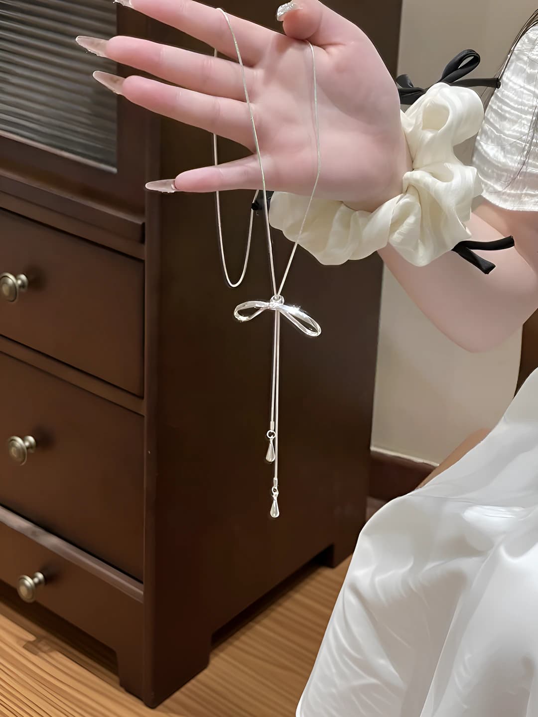 Women's long silver chain with bow and tassels