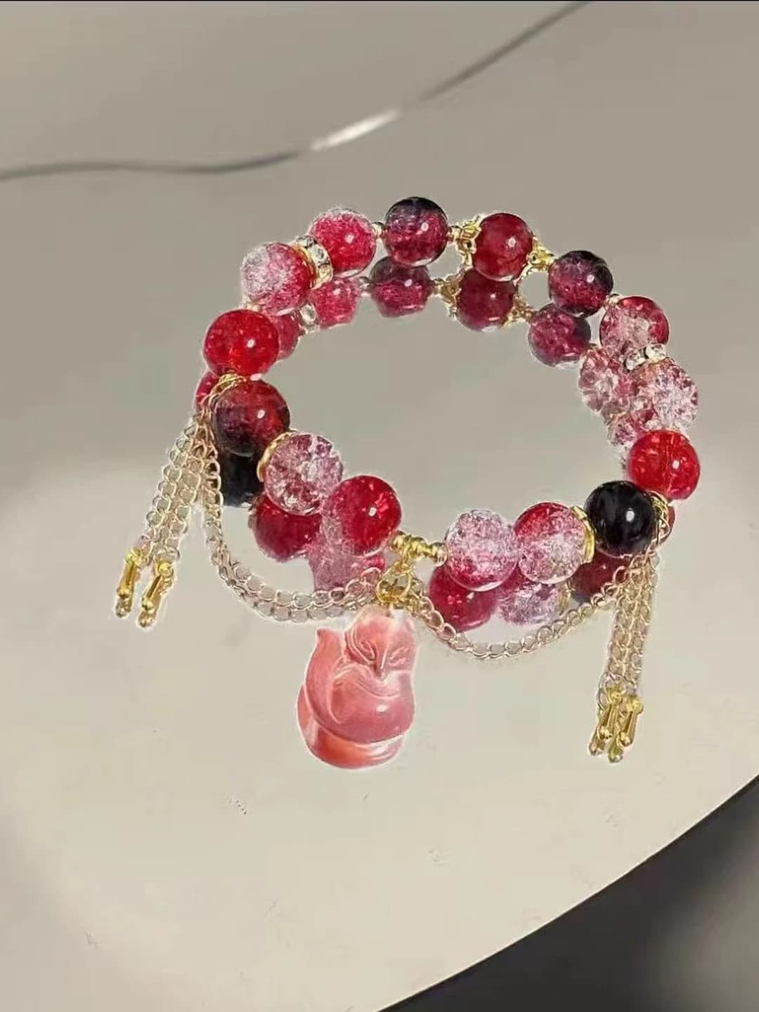 Women's handcrafted glass and lucite geometric beaded bracelet with tassel design element