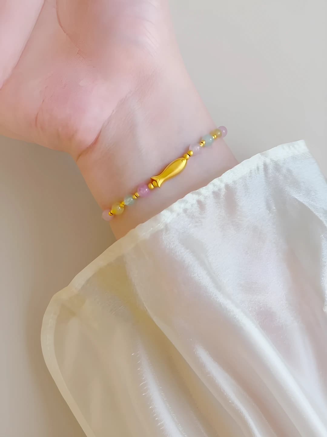 Women's beaded bracelet with gold fish charm and colorful stones