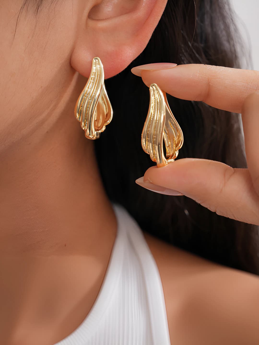 Women's earrings with geometric pattern and oval design element in metallic style