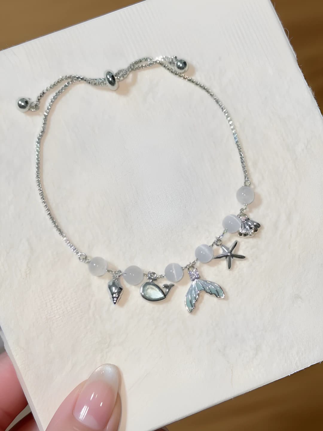 Women's spring-summer charm bracelet with cat's eye stone, starfish and shell design element