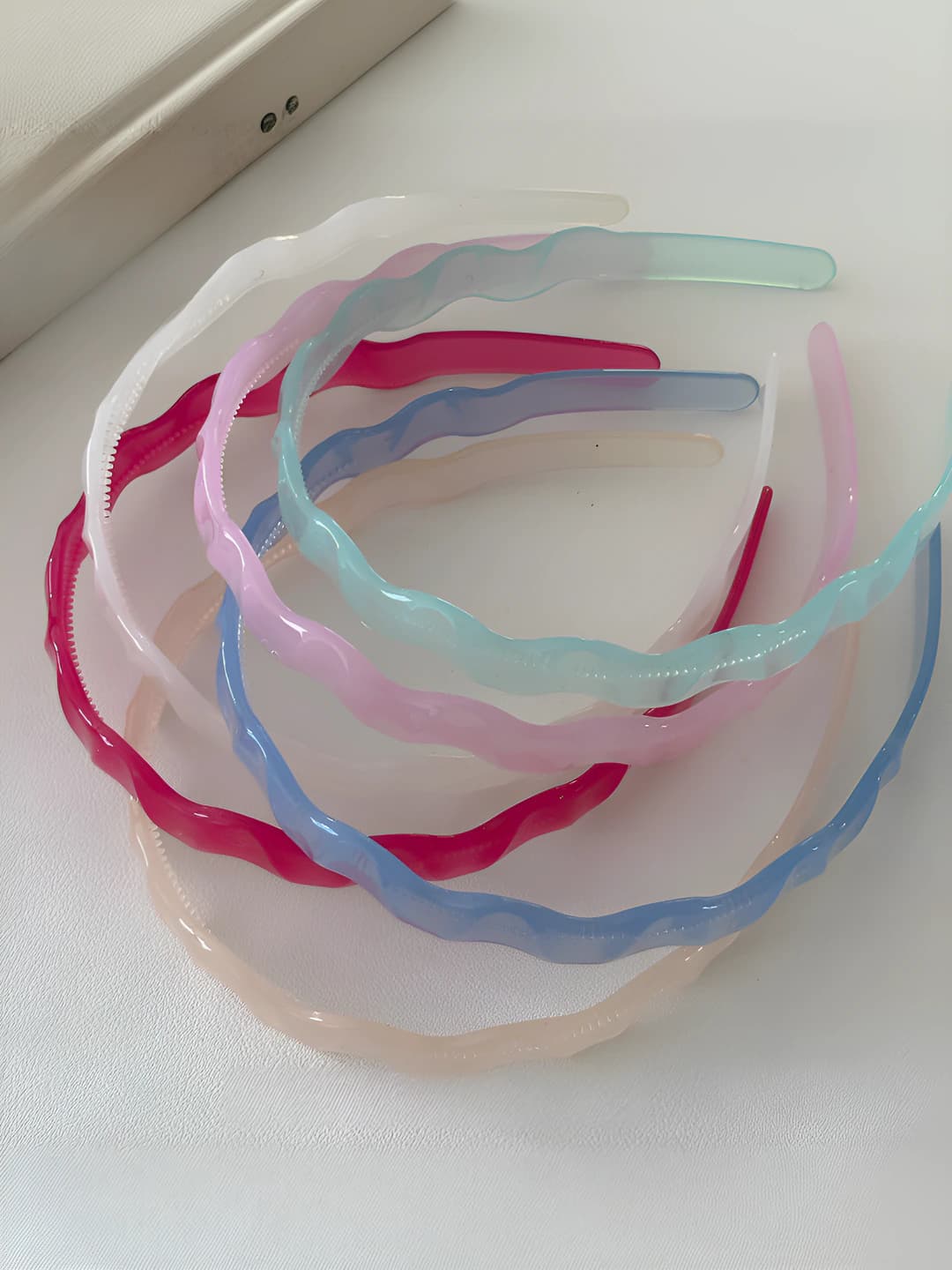 Women's non-slip headband made of plastic and resin with geometric design element
