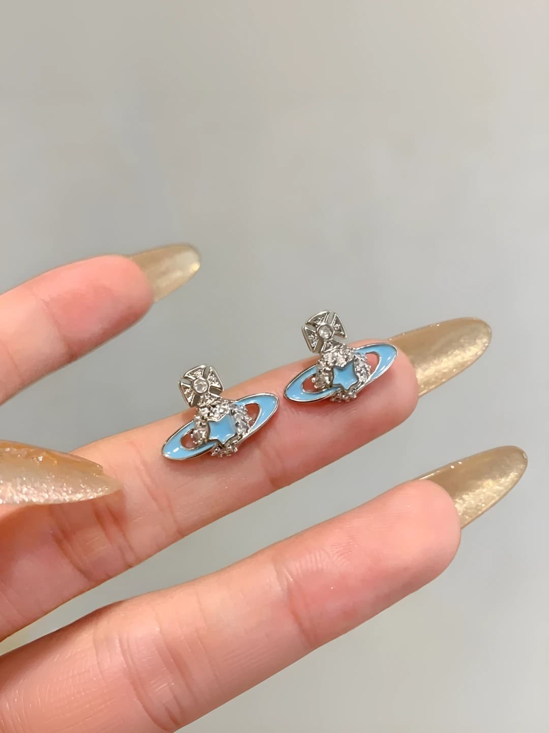 Women's 316L titanium steel stud earrings with blue Saturn design and zirconia