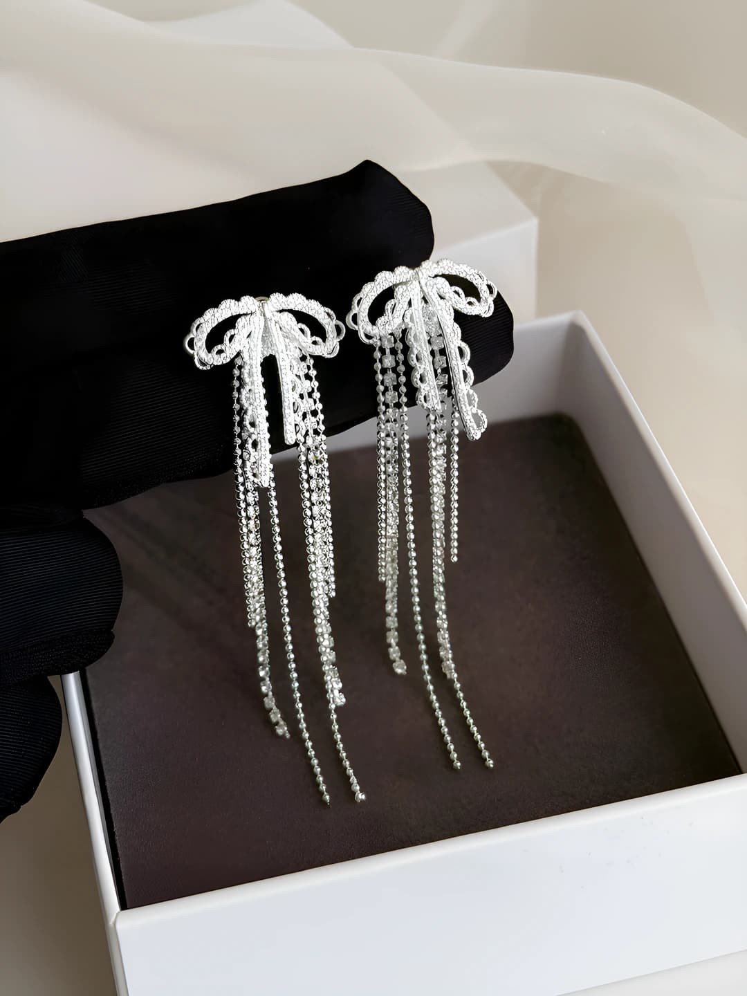 Women's earrings: steel post, zircon, bow, pearl and tassel design element, premium style