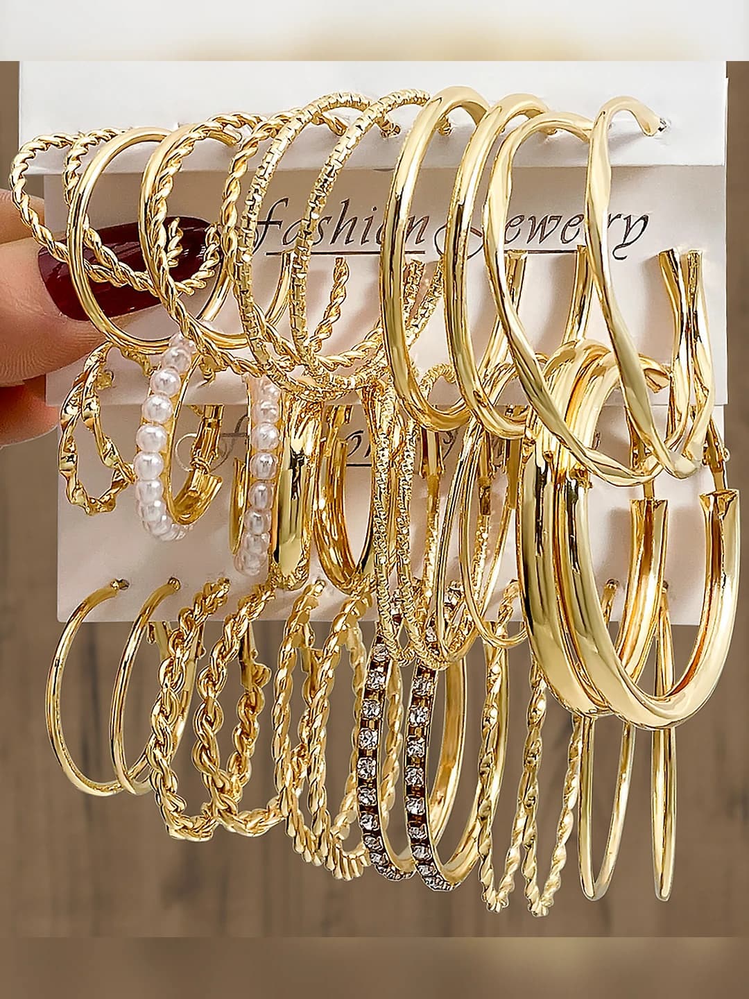Women's gold C-shaped metal hoop earrings with geometric design element and rhinestone inlays