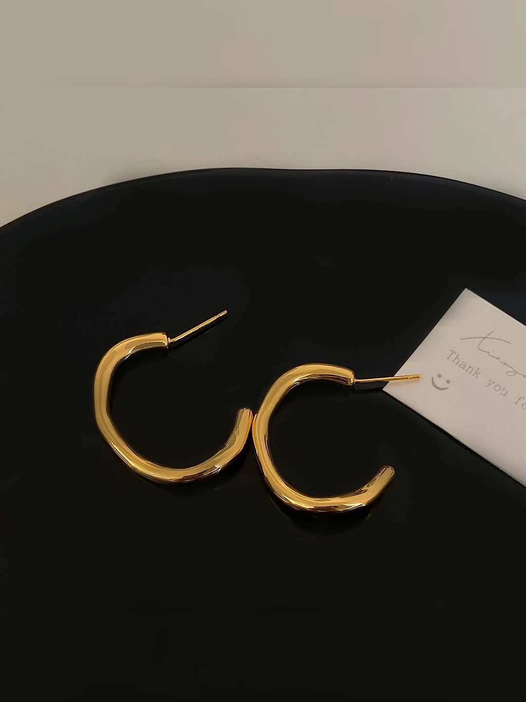 Gold twisted hoop earrings - glossy