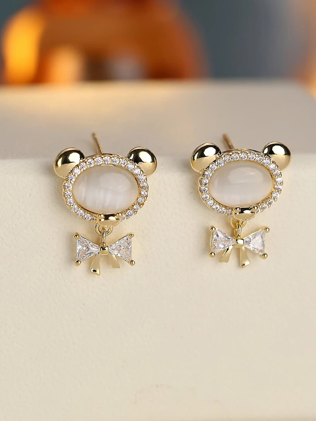 Women's copper and zircon earrings with bear and bow design element, minimalist style