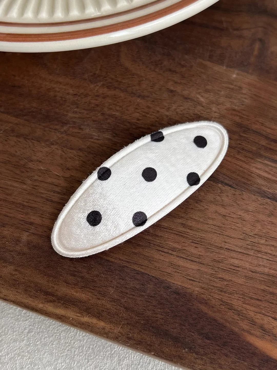 Oq fonda qora nuqtali oval