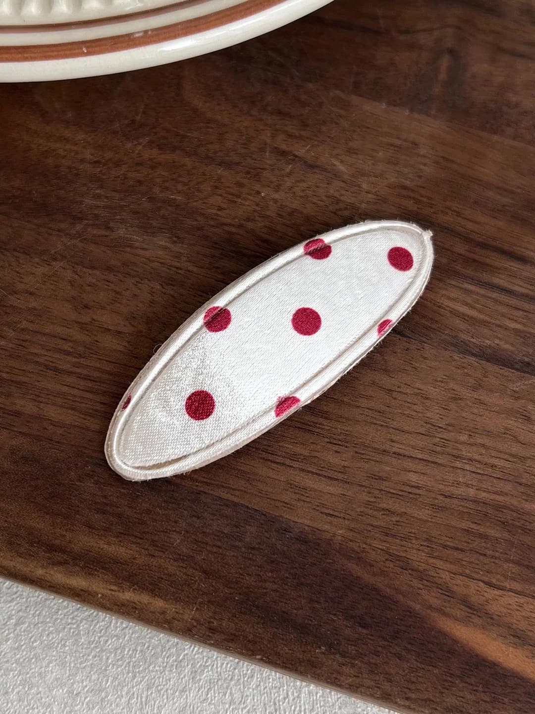 Oq fonda qizil nuqtali oval